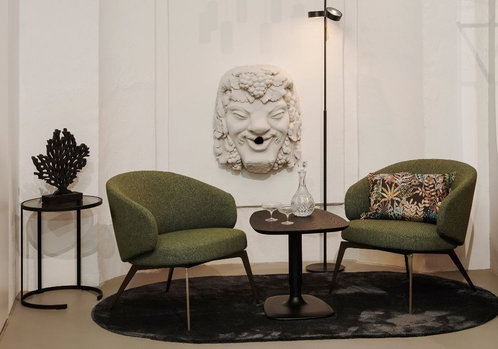 Moderne Küche mit weißer Kochinsel, grünen Regalelementen und stilvollen Dekorationen – Wohnatelier im Schlossquartier in Eisenstadt